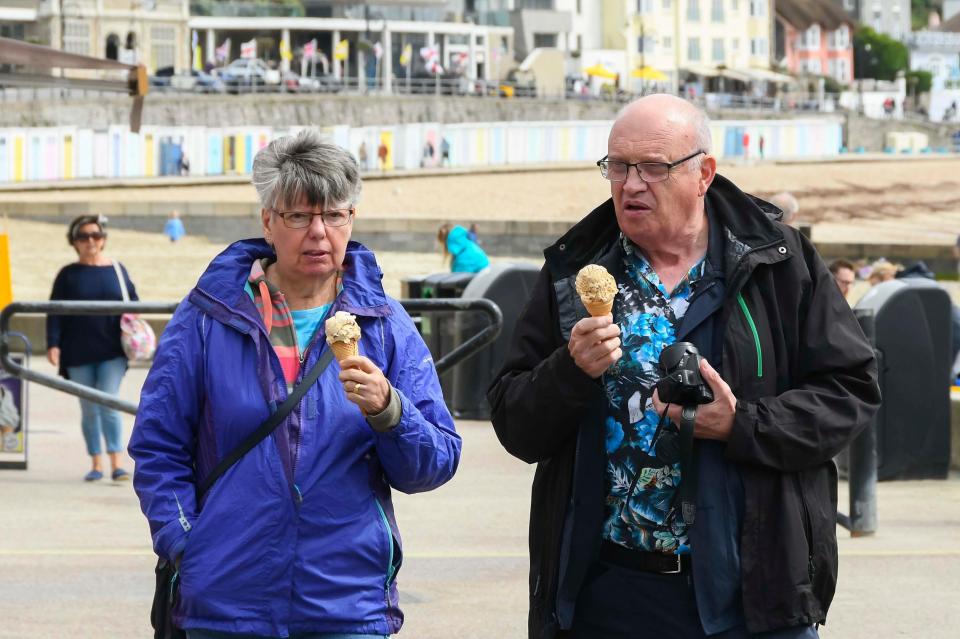  Visitors with ice creams at the seaside resort of Lyme Regis in Dorset on a morning of sunshine and showers