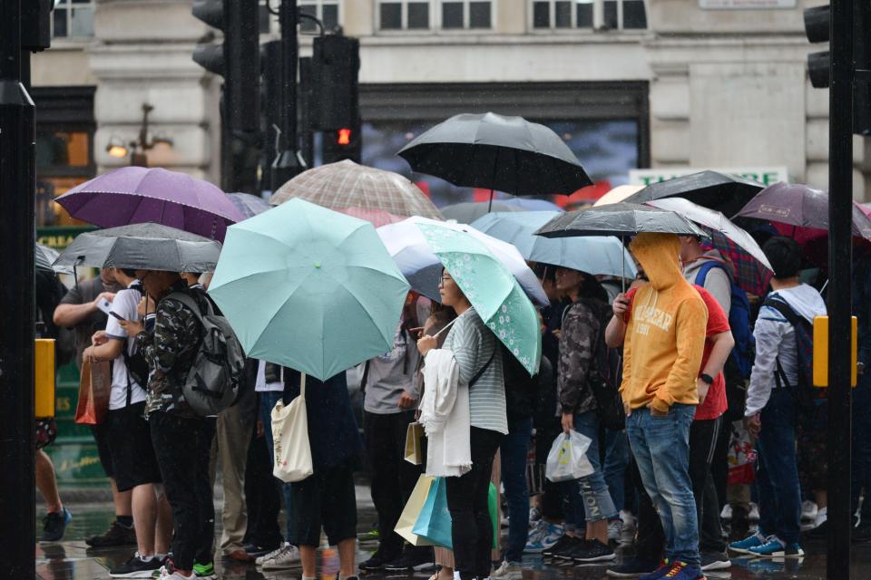  Summer shelter ... umbrellas were up in London as the rain came down