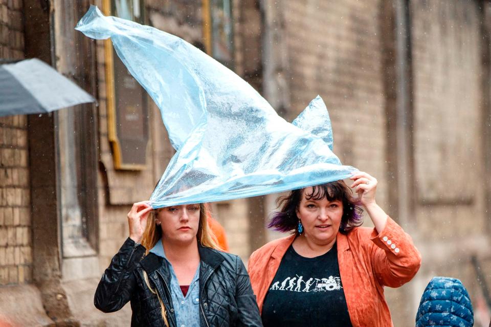  Women cover from the rain as inclement weather hits central London today