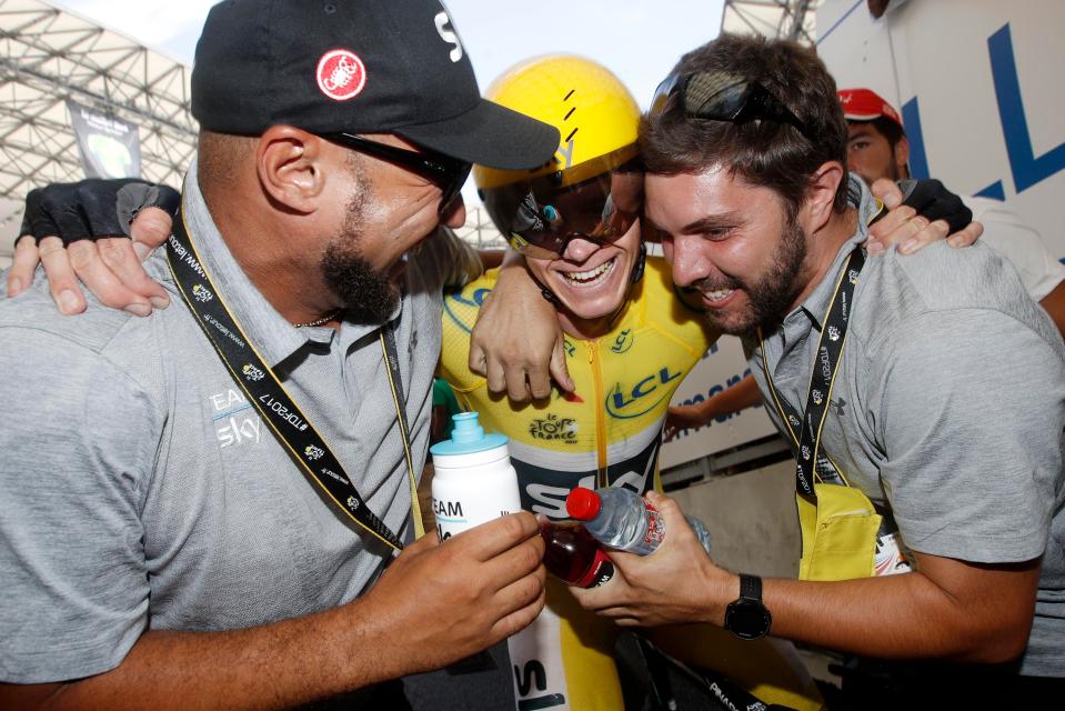  Chris Froome is mobbed by his Team Sky crew as he secures his fourth Tour de France victory