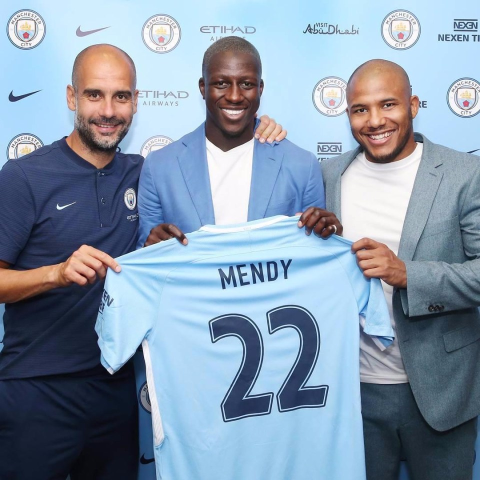 Benjamin Mendy stands with his Manchester City shirt alongside Pep Guardiola