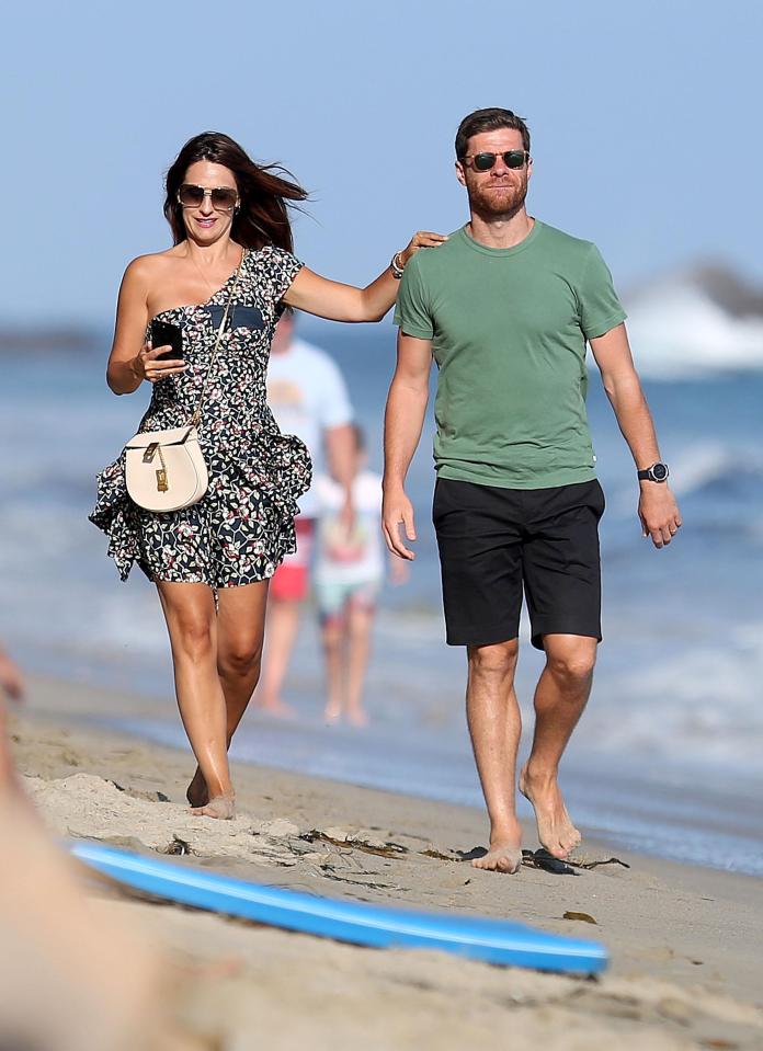 Nagore Aranburu and husband Xabi Alonso look cool as they stride along the beach in California