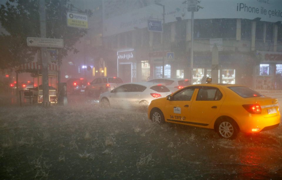  A taxi rolls through the streets as downpours broke out again in the evening