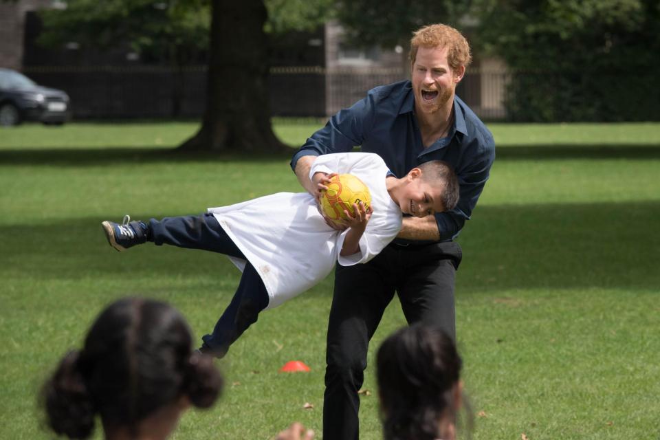  Prince Harry made this young lad's day as he swung him around during a park handball match