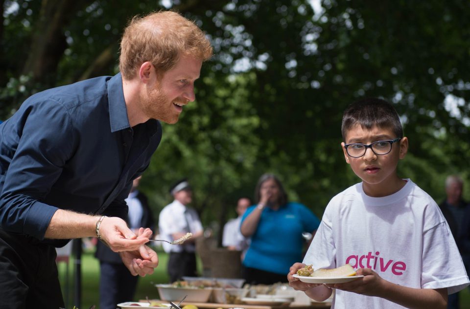  Taking his turn to serve lunch to the hungry kids, Harry told one youngster: 'So much to choose from, just take it all'