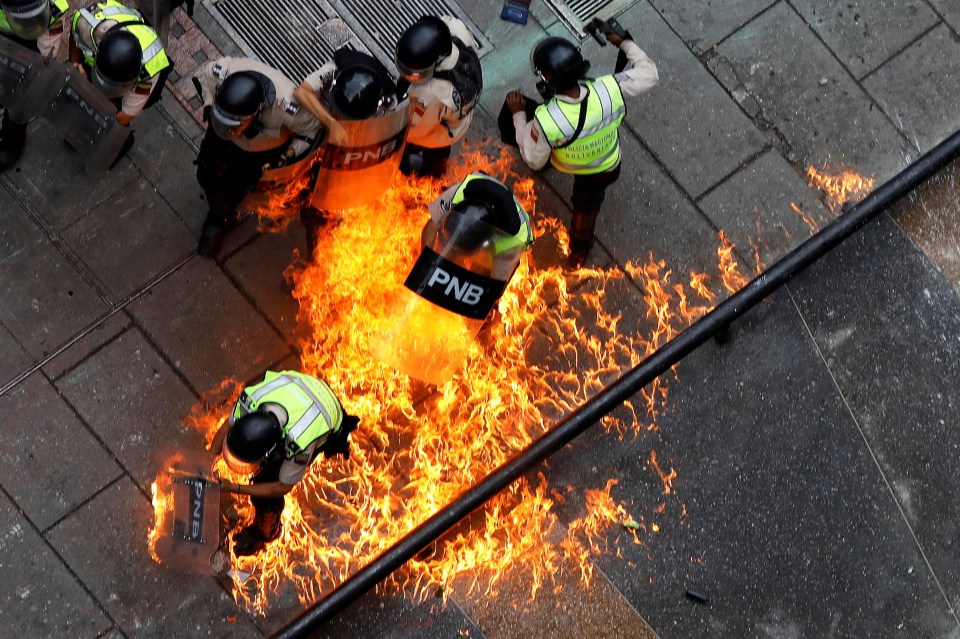 Riot security forces members catch fire during a rally against Venezuelan President Nicolas Maduro’s government in Caracas