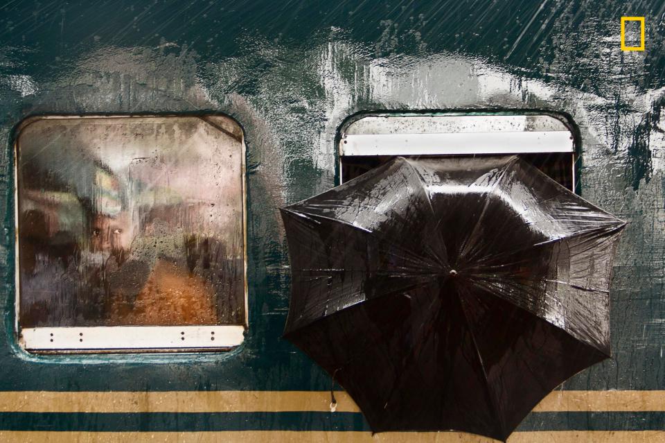  A train coming from Dhaka pauses at Tongi Railway Station in Gazipur, Bangladesh, on a rainy morning, where a pair of curious eyes looks through the misty window