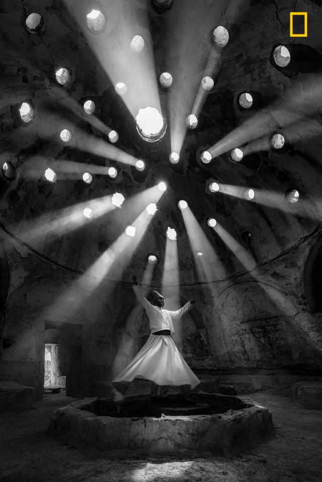  Beams of light filter through a historic building in Konya, Turkey, where a whirling dervish performs an ecstatic dance