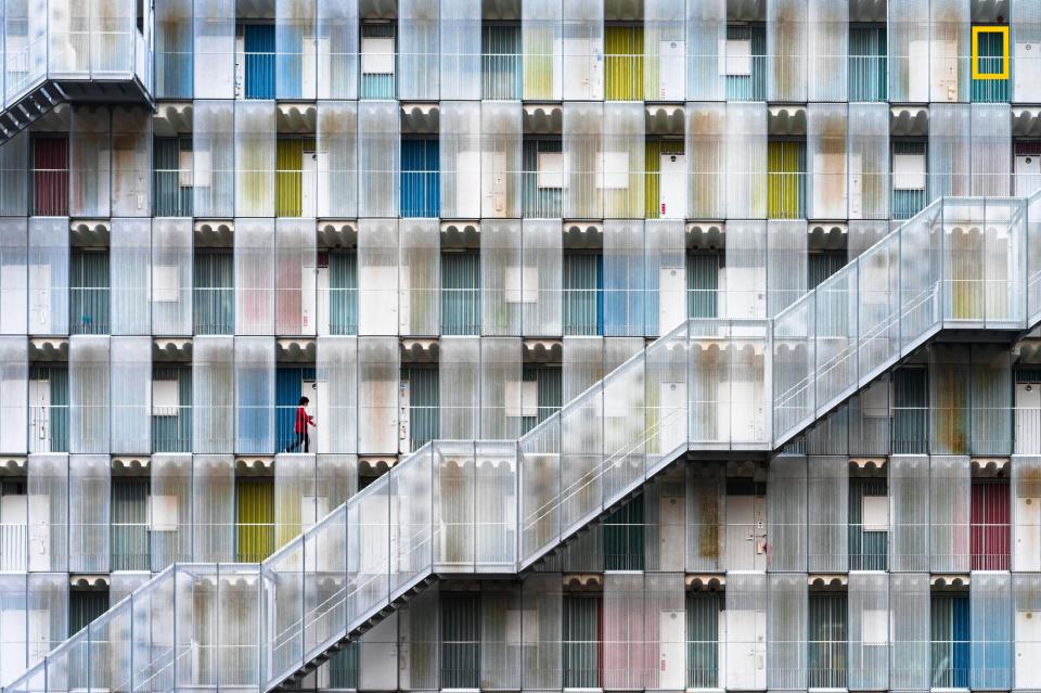  A woman walks along one of the outside corridors in a modern apartment complex in Gifu Prefecture, Japan