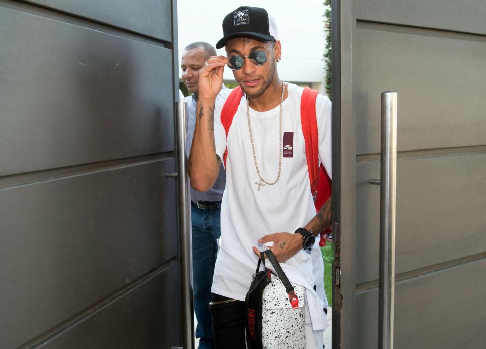 Neymar donned sunglasses and a hat as he headed for Barcelona airport