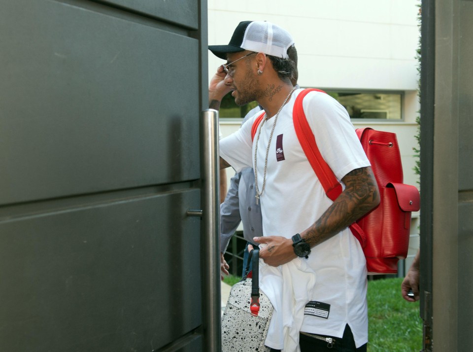 Neymar leans into his garden as he heads off in a taxi to Barcelona airport