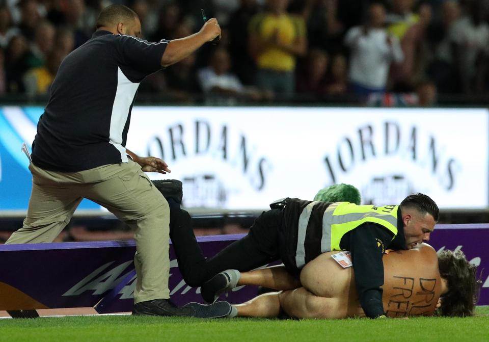  A steward tackled him to the ground over boards around the track