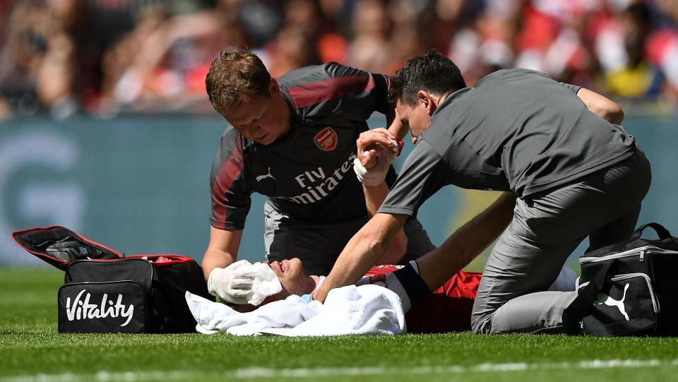  Arsenal physio Colin Lewin rushed onto the pitch to treat Per Mertesacker's facial injuries