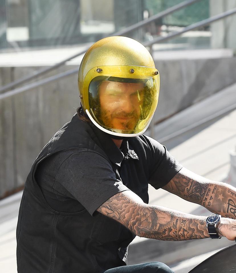  He wears space-age style headgear on his vintage motorbike