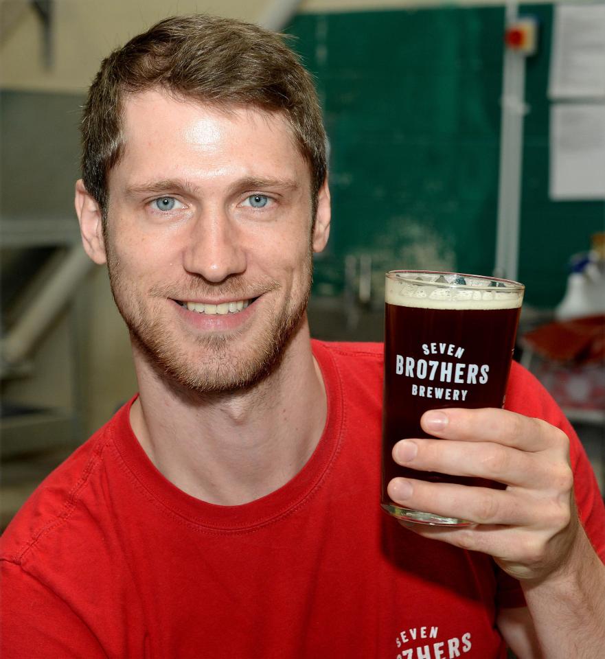  Greg McAvoy, 33 holding up a pint of beer brewed by his family business