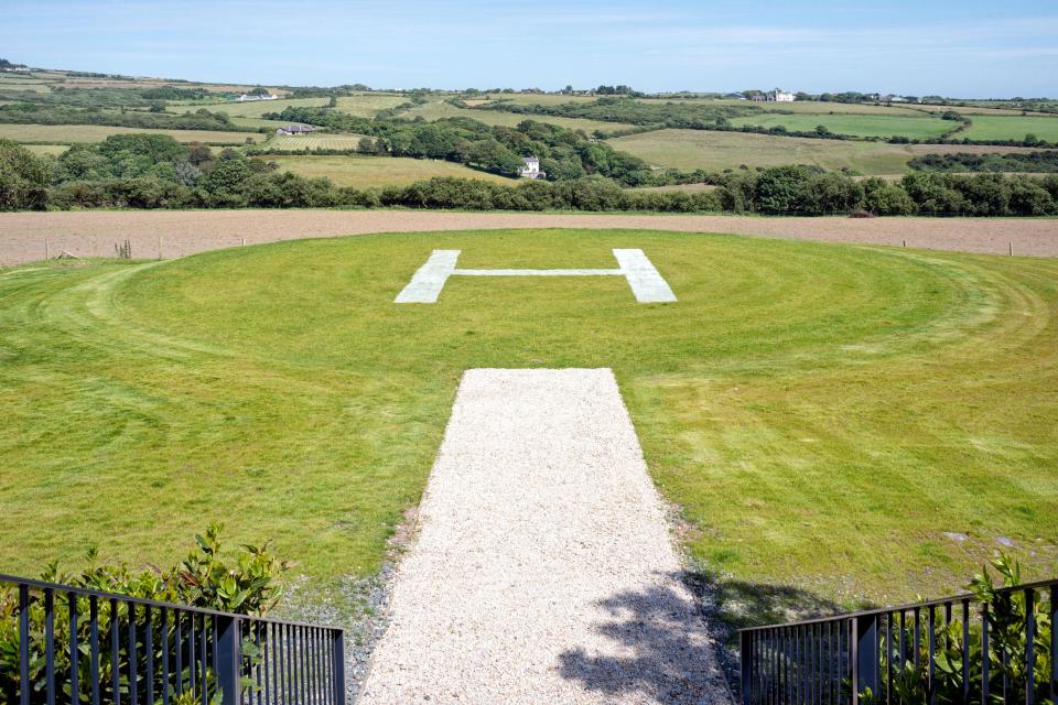 A helipad sits within the mansion's lush grounds