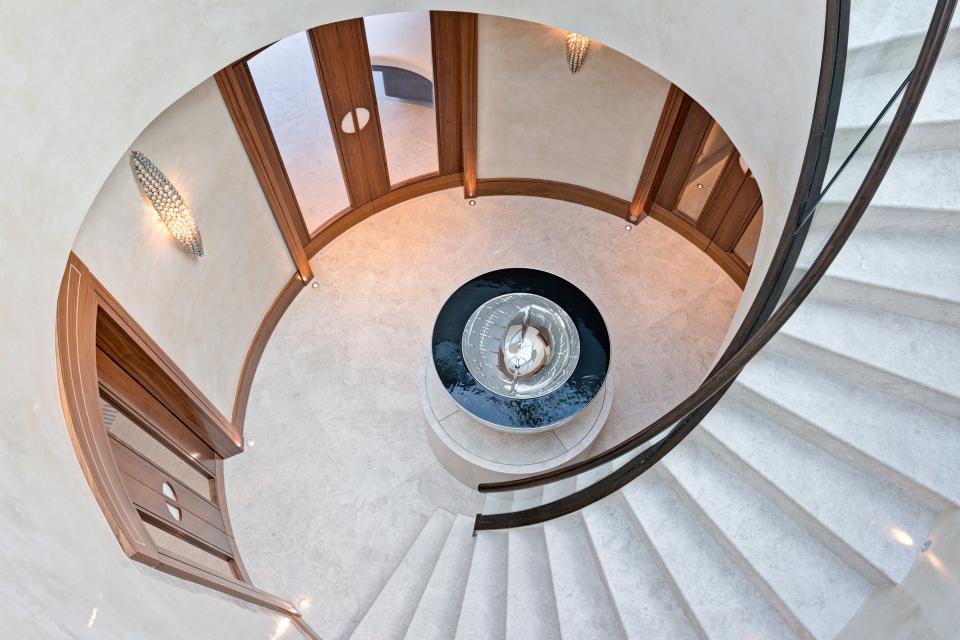 The spiral staircase leads up to the gym, which is kitted out with cross trainers, running machines and weights