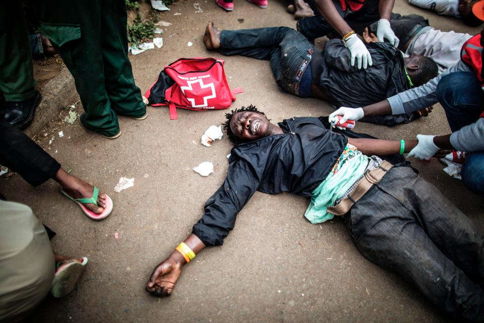  Emergency workers take care of the wounded after 15 people were 'beaten during a police raid', in Mathare