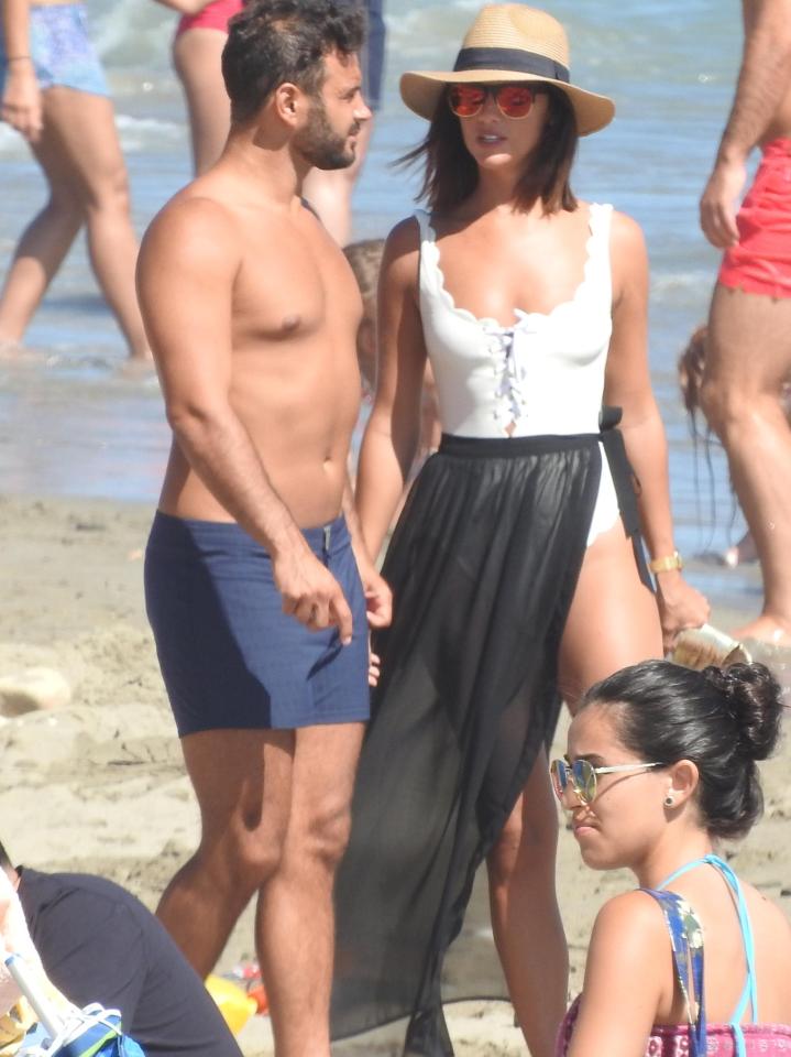  The former Towie star sizzled in a white vest top and revealing sarong while her hunky boyfriend opted for blue swim shorts