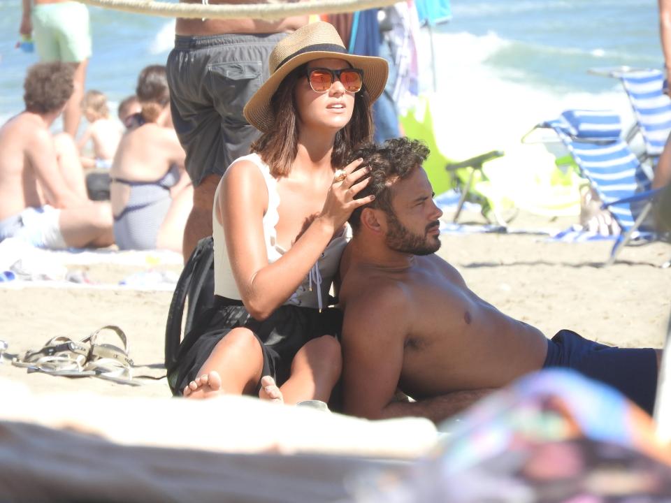  Lucy, 26, affectionately stroked Ryan's hair as they soaked up the sun