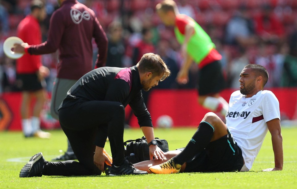 The West Ham defender winces in pain after being struck down by injury