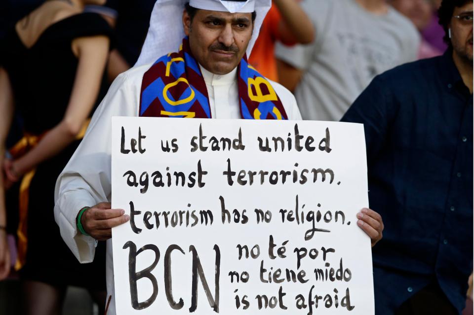 A Barcelona fan holds up a sign against terrorism at the Nou Camp