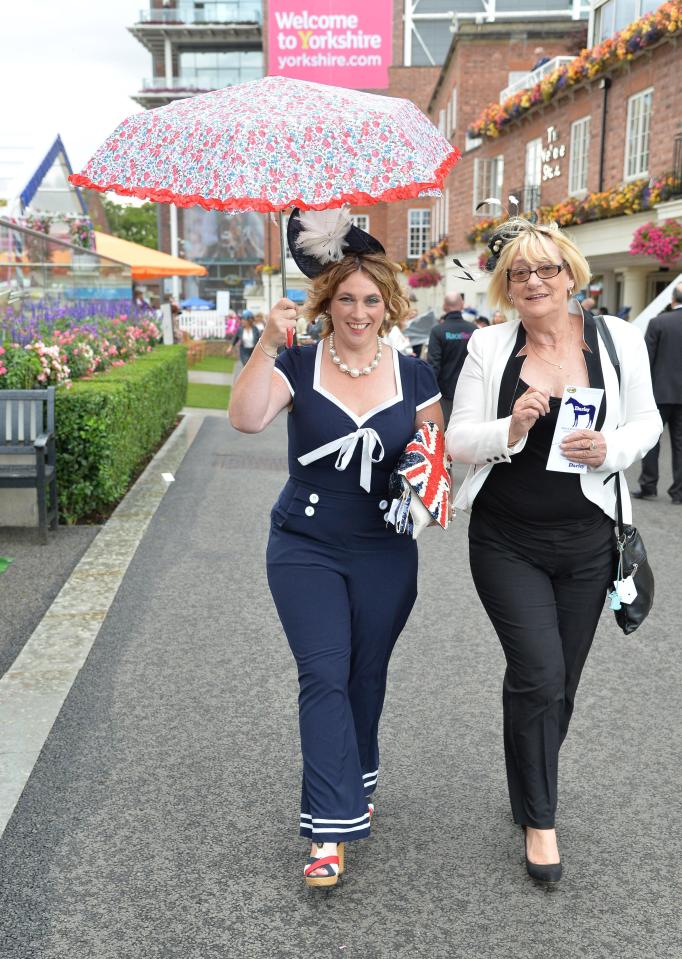  One woman in a nautical inspired navy jumpsuit struggled to keep hold of her brolly as the wind picked up