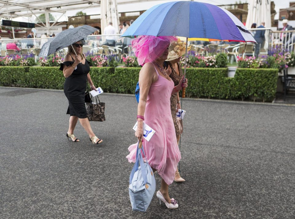  Racegoers hid under giant umbrellas as they made their way to the stalls