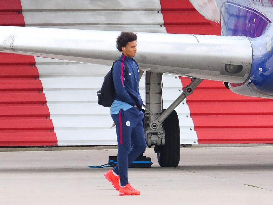 Leroy Sane heads for the plane....with his hands down his tracksuit bottoms