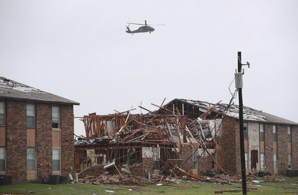  A helicopter flies over a destroyed apartment complex after Hurricane Harvey passed through