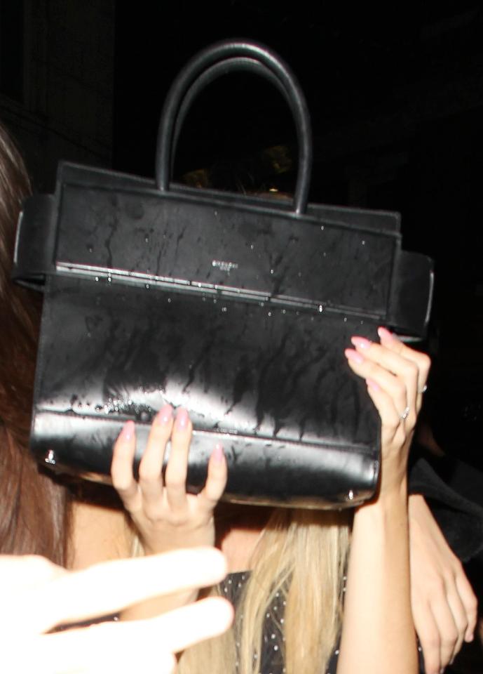  The model used her posh designer handbag to protect her face