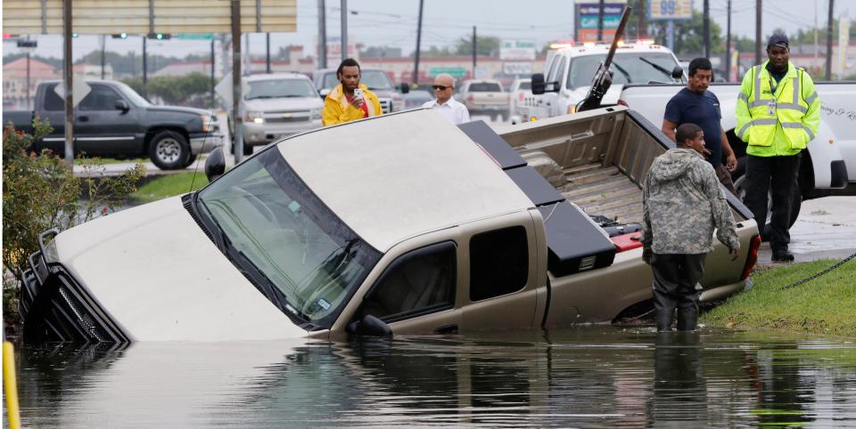 A pick up truck is towed out of a flooded ditch in Houston