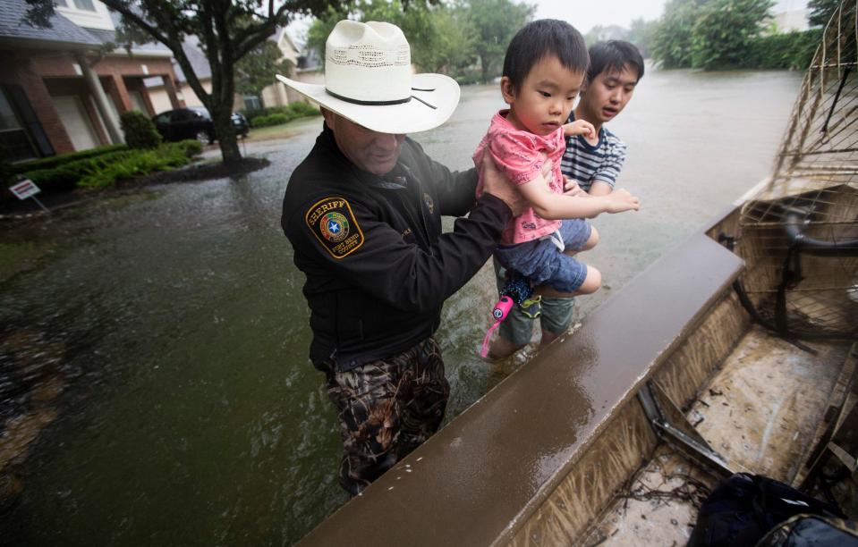 Fort Bend County Sheriff Troy Nehls and Lucas Wu lift Ethan Wu into an airboat