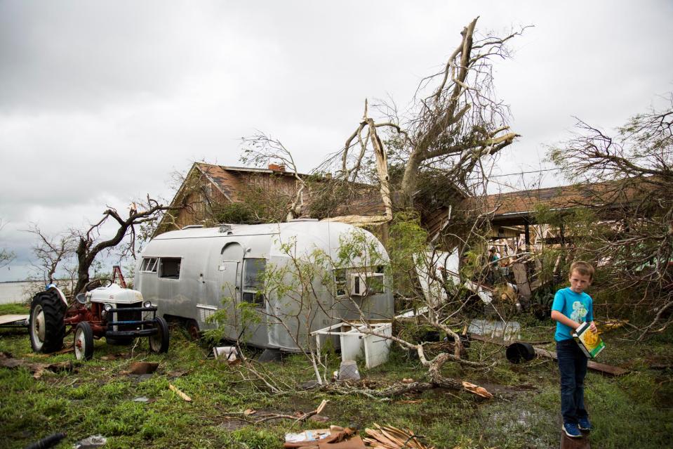 Corey Carpenter, 7, eats crackers in what used to be his cousin's yard in Bayside, Texas