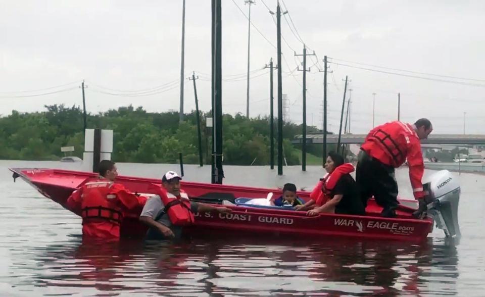 A Coast Guard flood punt team staff help rescue residents from flooded areas