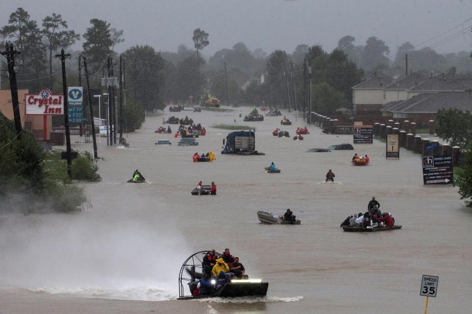 Residents use their boats to evacuate flood waters just east of Houston