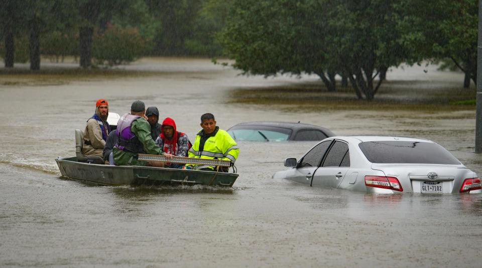  Rescue workers bring in a family through rising flood waters in the Cypress Station neighbourhood of Houston