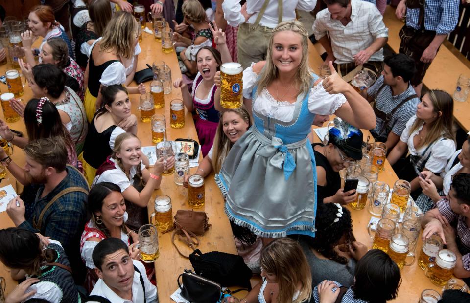  People drink the first of many mugs of beer to be handed out at the festival