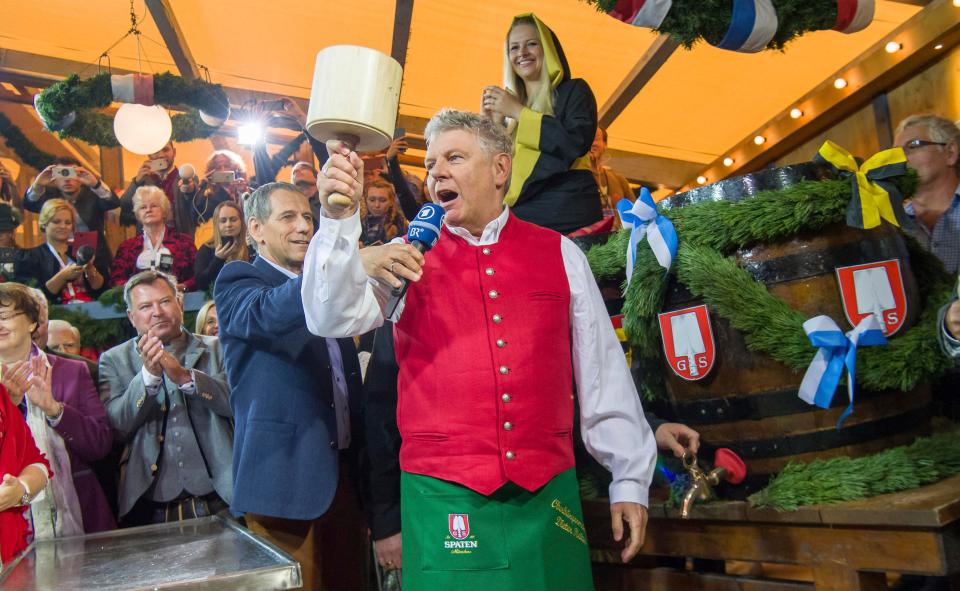  Munich's Mayor Dieter Reiter, centre, taps the first beer barrel during the Oktober fest opening