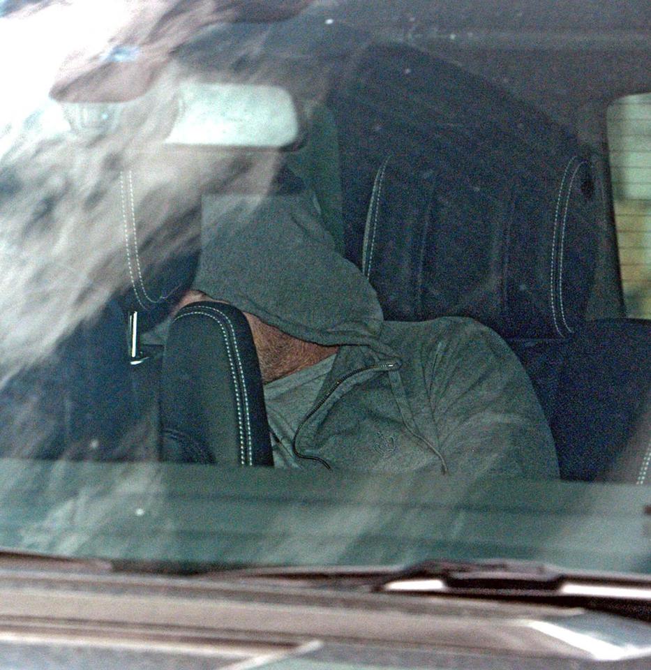  Wayne Rooney hides his face wearing the same clothes as he is driven out of Middlewich custody suite in Cheshire on Friday