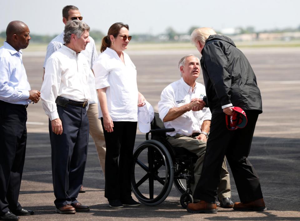 Trump greets Texas Governor Greg Abbott after arriving at Ellington Field