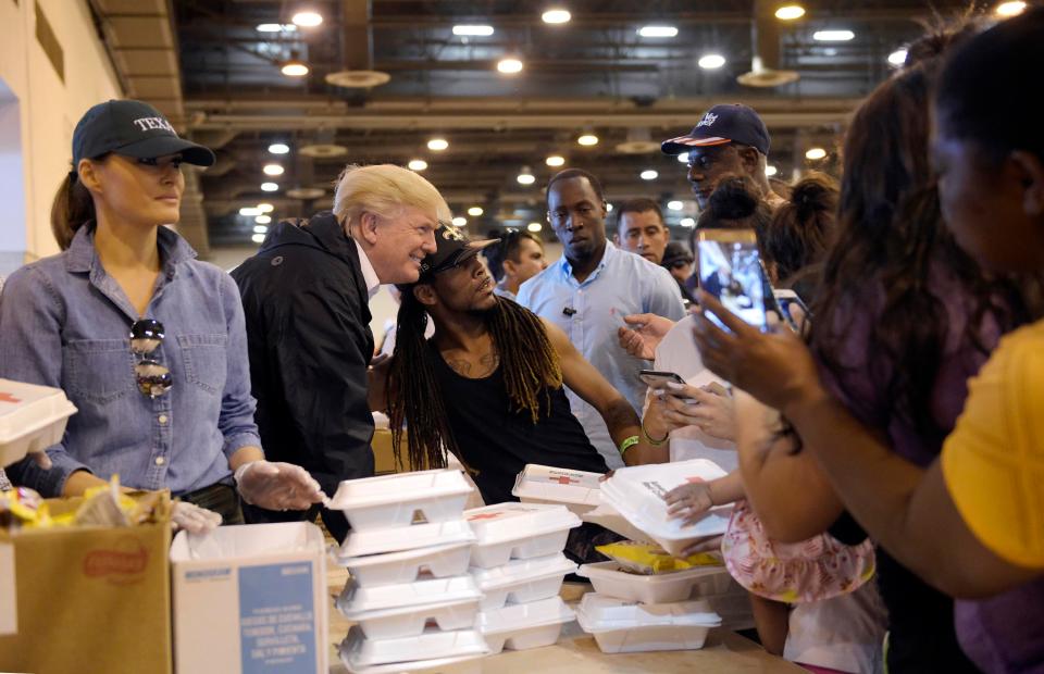 The Donald poses for a photo with a victim with Melania hands out food