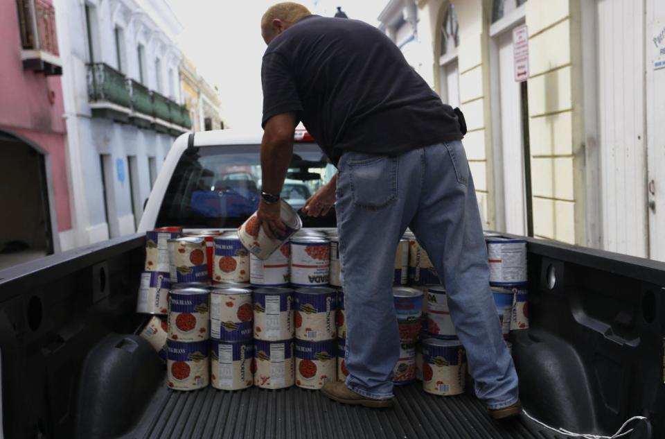  A man carries cans of food in a van to take them to the shelters in San Juan