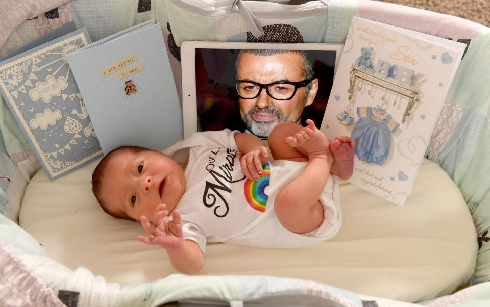  My 'pop' ... Two-week-old Seth with photo of caring singer George Michael who donated £9K for IVF