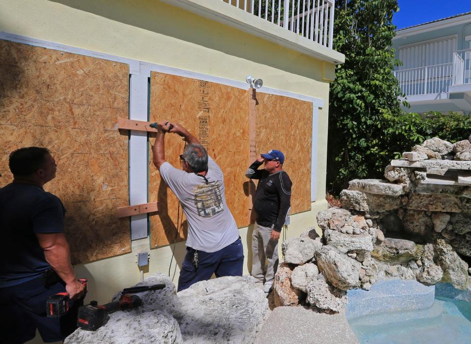  Families out up hurricane shutters at a home in Key Largo, Florida