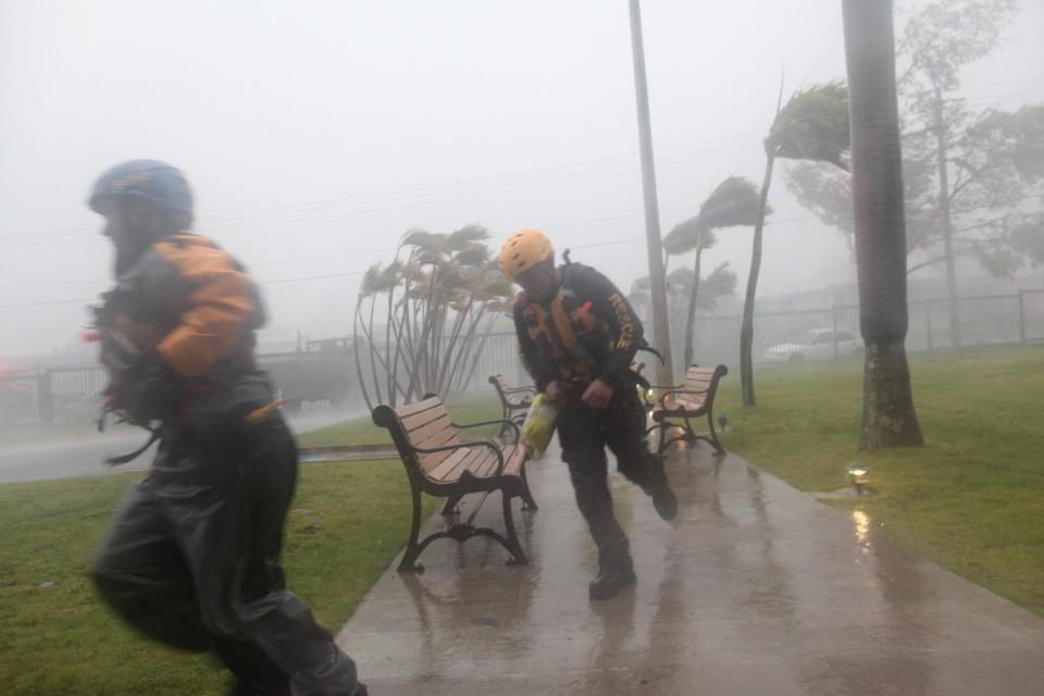  Members of the civil defence run as Hurricane Irma howls past Puerto Rico