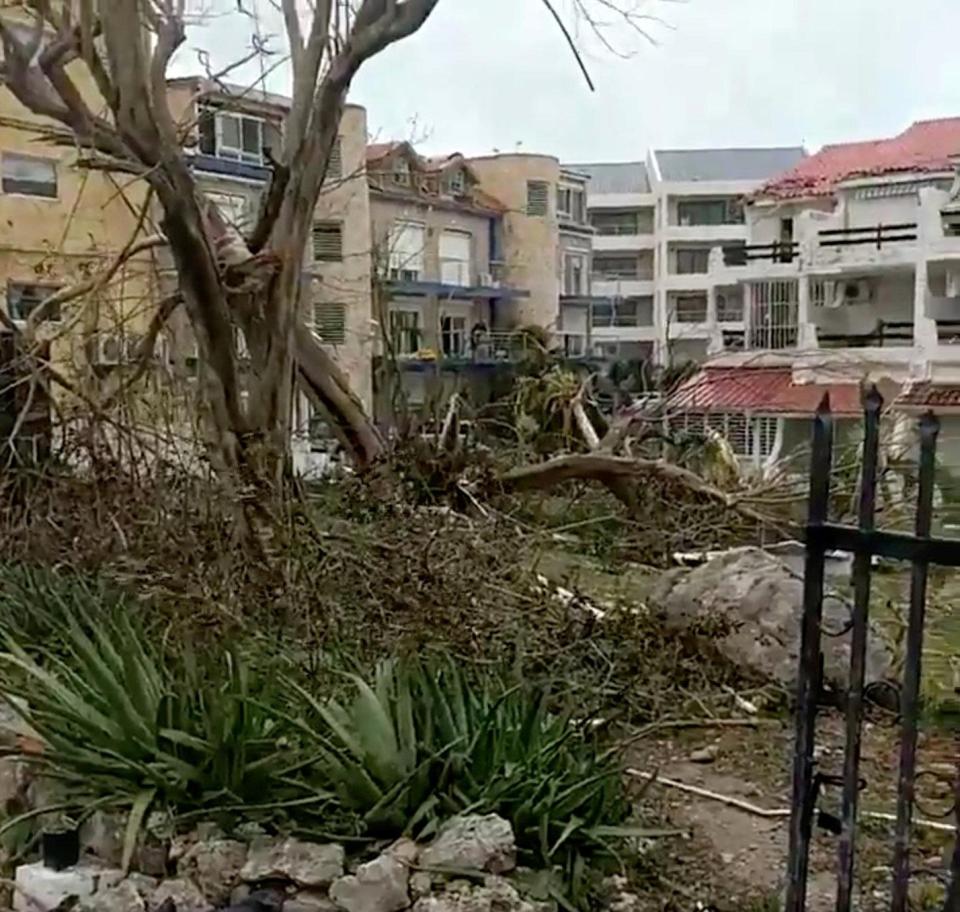  Upturned trees and battered apartment blocks on the Dutch side of the island