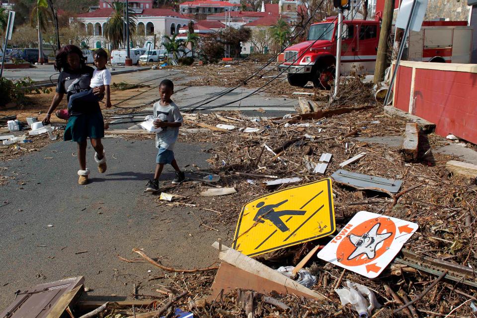  A woman with her two children walk past debris left by Irma in Charlotte Amalie, St Thomas