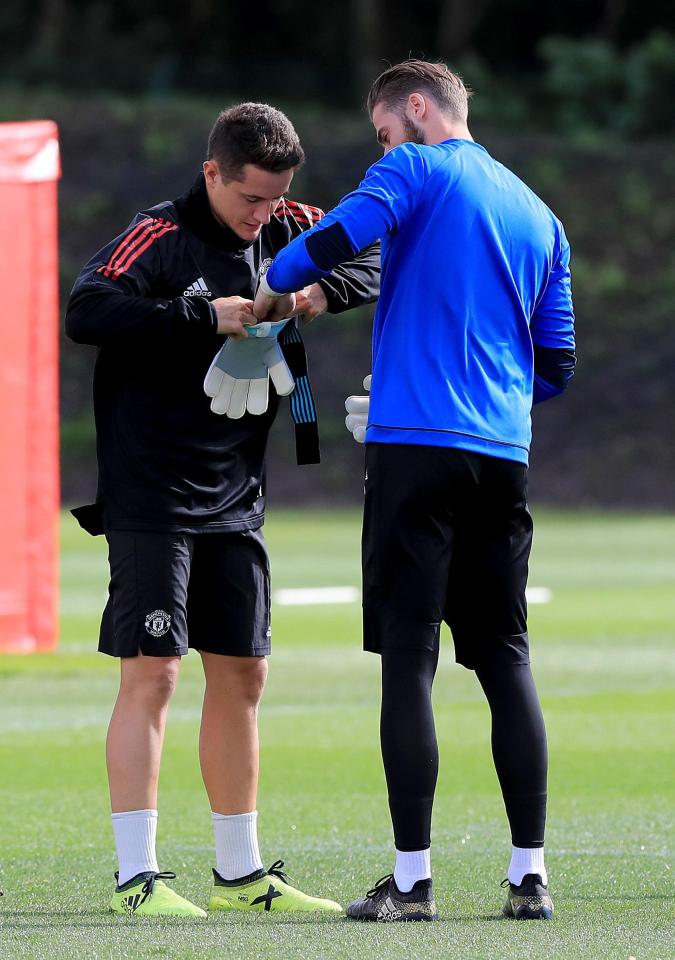  Herrera helps his Spanish compatriot get his gloves on at the United training centre