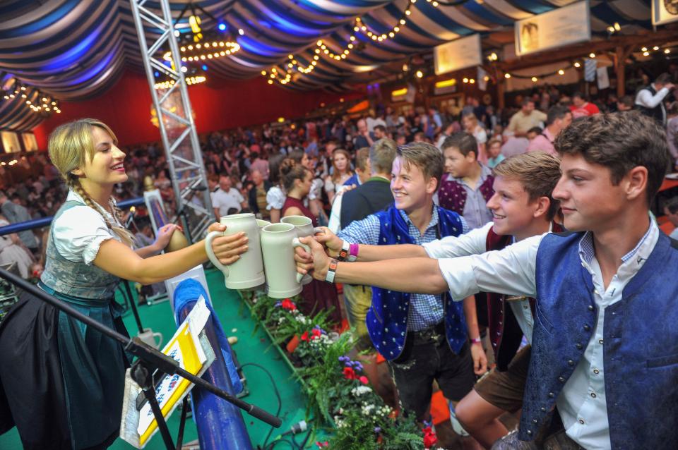 Deni shares a stein with a group of male Oktoberfest revellers